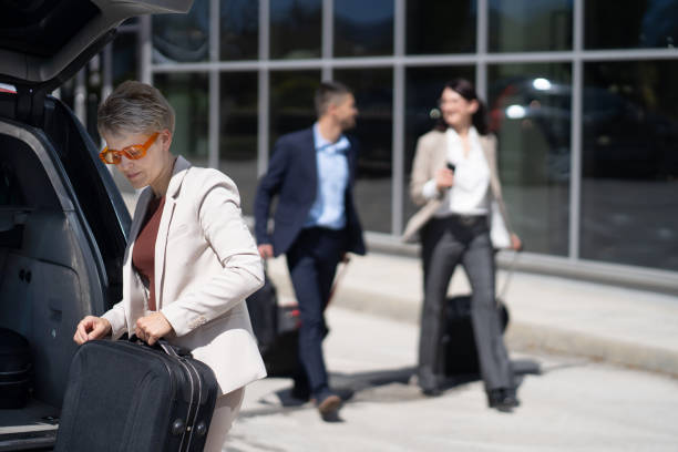istock A senior woman is loading her luggage in a car 2130064172