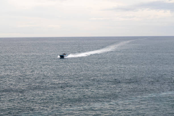 The boat in the sea, waves trace in the calm water