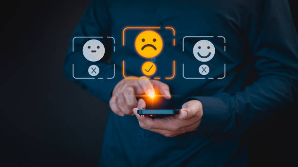 istock Engaging in an online customer feedback survey, a user utilizes their mobile phone to display an angry emoticon on a virtual screen, sharing their opinion and reviewing service satisfaction. 2130107714