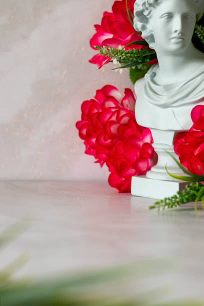 istock Roman plaster bust with red rose flowersle floor, copy space 2130125997