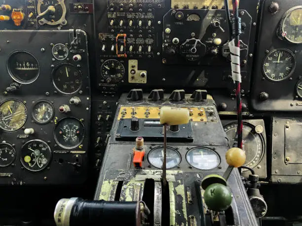 Photo of The cockpit control panel of the old plane close up. Detail of an old airplane cockpit with various indicators, buttons, and instruments. Lots of buttons and levers on the aircraft control panel