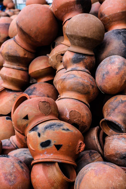 istock pots are gathered and arranged in a pattern in the empty space. The potter works on a pottery wheel to made of soft colored clay, retro style toned Clay pots with hand and equipment 2130218618