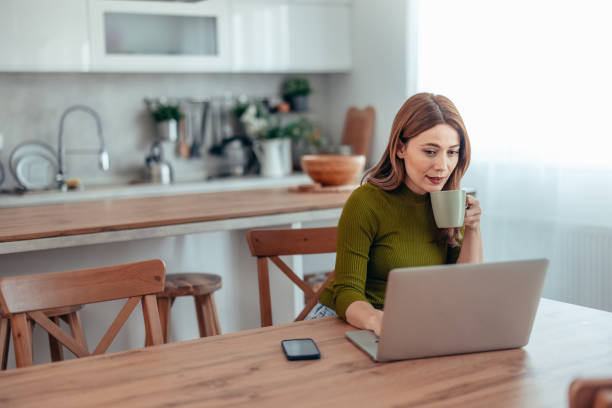 istock Woman using laptop while sitting at home 2130231344