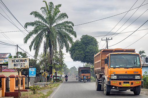 Medan, Sumatra, Indonesia - January 18th 2024:   Trucks driving through a small suburb to Medan, the main city on North Sumatra