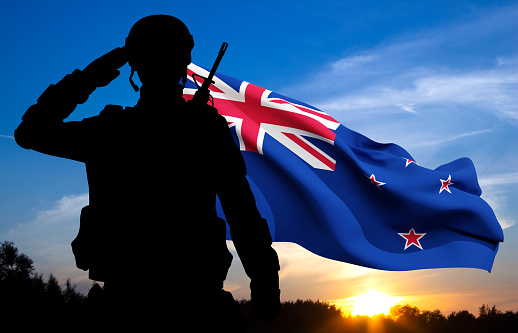 Silhouette of a saluting soldier with New Zealand flag on background of sky. Background for Remembrance day