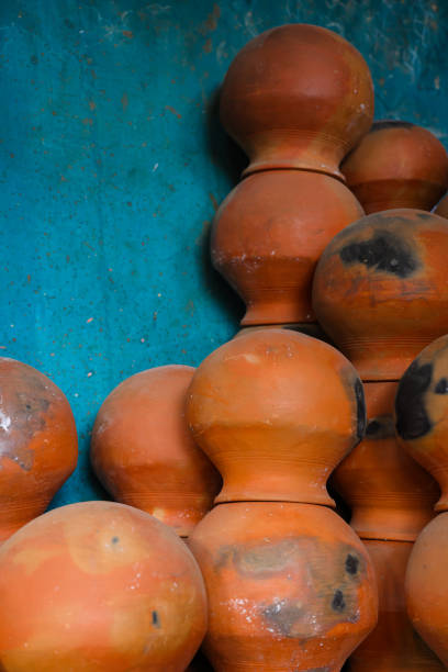 istock pots are gathered and arranged in a pattern in the empty space. The potter works on a pottery wheel to made of soft colored clay, retro style toned Clay pots with hand and equipment 2130238956