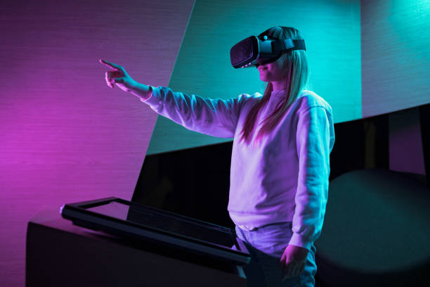 istock Girl in a virtual reality headset making hand gestures in the air 2130286789