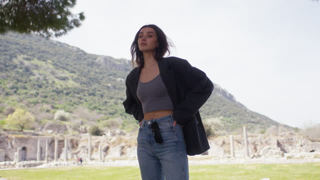 Fashion portrait of young tourist woman in a historical archeological ancient town ruins.