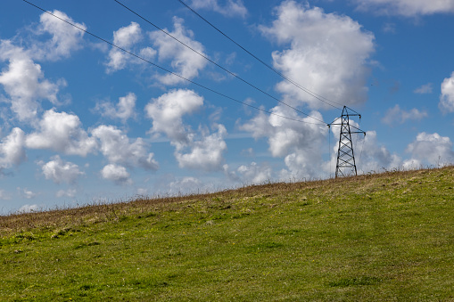 An electricity pylon in the Sussex countryside, on a sunny early spring day