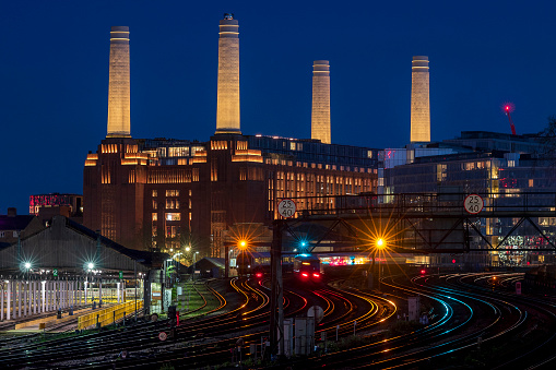 Long exposure of trains outside Victoria Station with newly refurbished Battersea Power Station in the distance.The Power Station is now a retail, entertainment and residential destination.