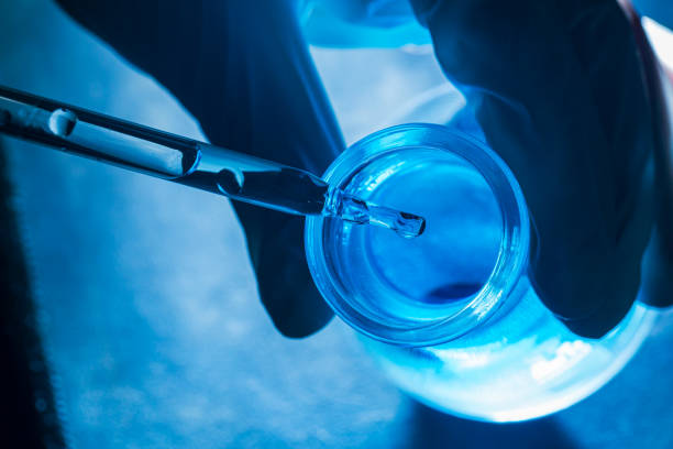 istock Macro blue science experiment,Close up view macro shot of gel with different sized bubbles comes out from lab dropper into petri dish on blue background 2130354634