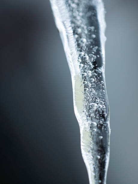 Icicle with water flowing down it, close-up.