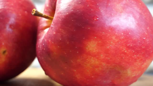 A few wet red apples, 4k macro video. The apples are spinning.