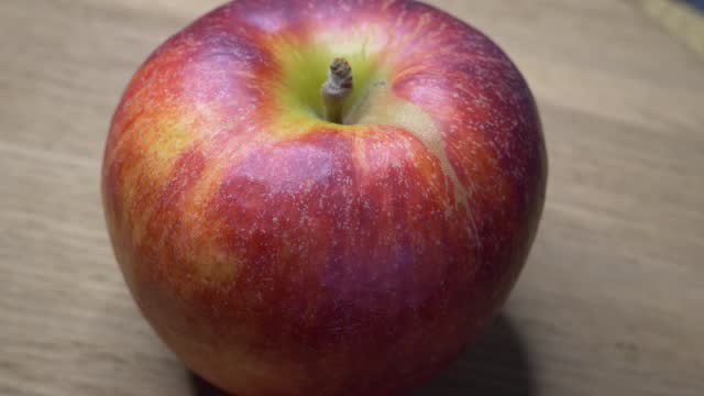 One large ripe gala apple in close-up. Video with red apple.