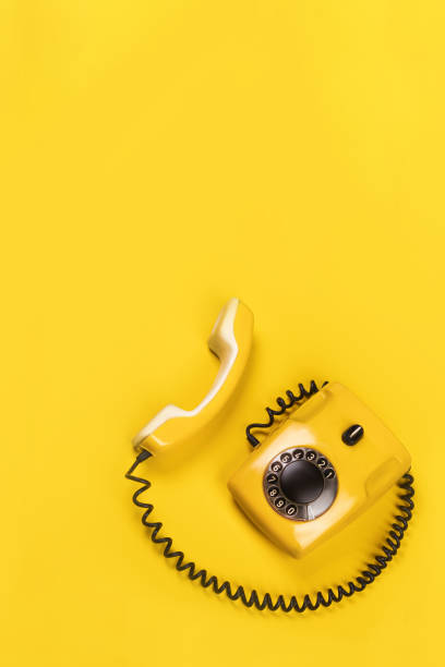istock Vertical banner with old yellow phone with hard shadows on yellow background flat lay copy space for you text 2130426851