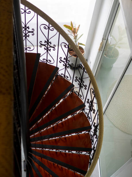 istock Narrow winding metal staircase with red steps against white background 2130426861