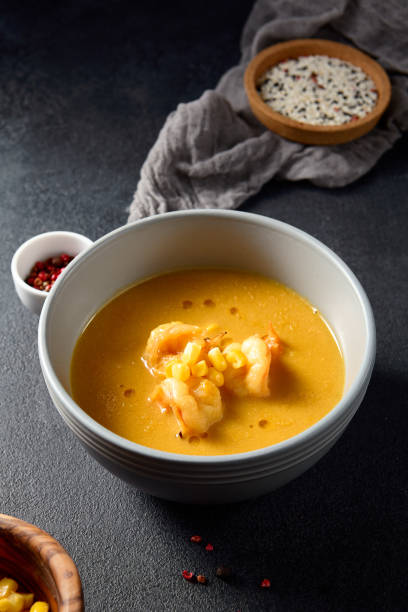 istock Shrimp and corn curry in a grey bowl with side condiments, a focus on modern Asian cuisine 2130467064
