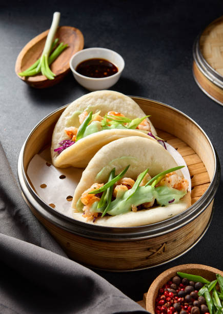 istock Steamed Bao buns filled with shrimp, purple cabbage, and wasabi, served on a dark table setting 2130467071