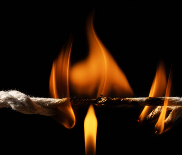 istock Burning frayed rope at breaking point on black background 2130496198