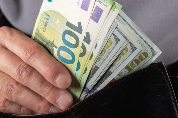 istock Man handing wallet with 100 euro and 100 dollars banknotes 2130499872