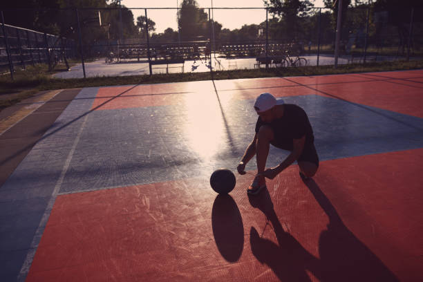 istock Man making pause after playing basketball on a open public court 2130510361