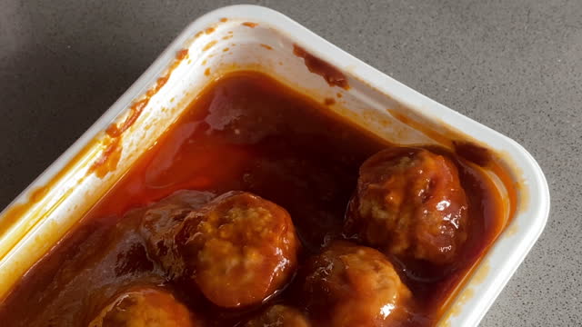 Meatballs with sauce in plastic container