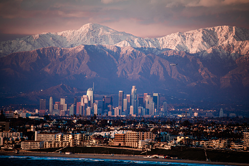 Snow capped mountains behind Downtown Los Angeles .