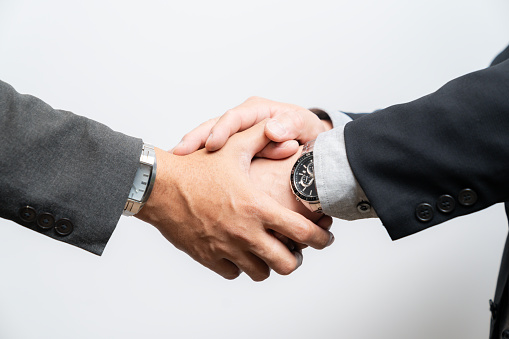 Closeup shot of businesspeople shaking hands in an office.