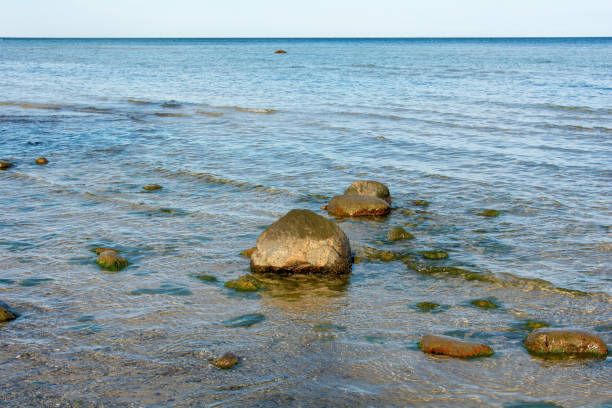 Big rock with stones lie in the water, at low tide  on the coast of the Baltic Sea