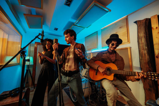 Studio session with three funky artists Three funky artists having a studio session while playing guitar, harmonica and singing cheap artists in music stock pictures, royalty-free photos & images