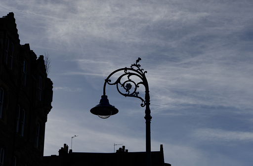 Edinburgh Scotland 09 November 2023: Low angle view comprising silhouette of ornate lamppost against overcast sky