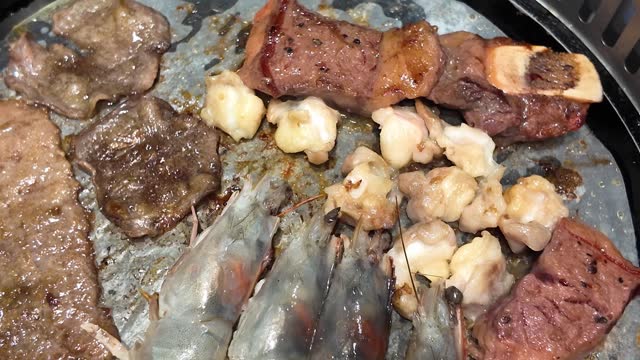 Close ups of Korean style meat and seafood barbecue