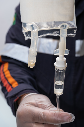 Nurse preparing anti-inflammatory medication to administer intravenous therapy to the patient.