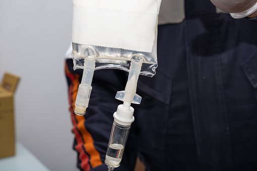 Nurse preparing anti-inflammatory medication to administer intravenous therapy to the patient.