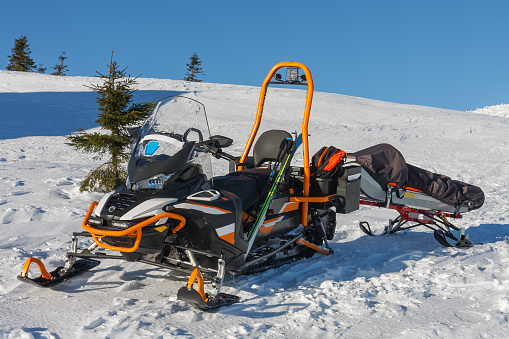 Snowmobile with stretcher mountain rescue service in front of cottage vyrovka in krkonose mountains.
