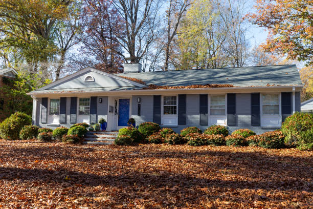 istock Neutral American ranch house and yard deeply covered in fall leaves, yard maintenance creative copy space 2130658547