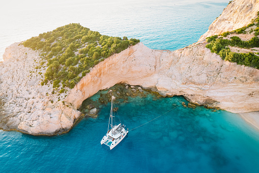 Drone view of sailboat in clear blue water in Greek island. Vacation concept