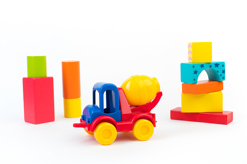 Children's toys, multi-colored car, wooden constructor cubes on a white background. For the development of the child.