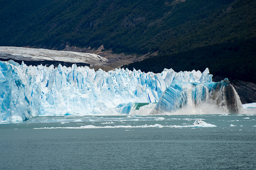 Large chunks of ice break from the Glaciar Perito Moreno creating an amazing colorful effect and waves