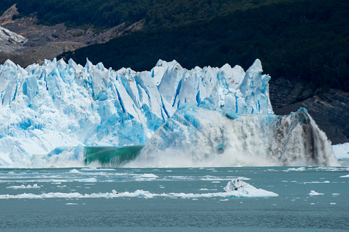 Large chunks of ice break from the Glaciar Perito Moreno creating an amazing colorful effect and waves