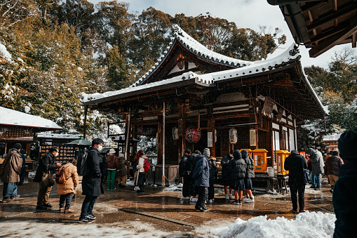 Kyoto, Japan – January 25, 2023: People standing in snow in front of vintage building during winter