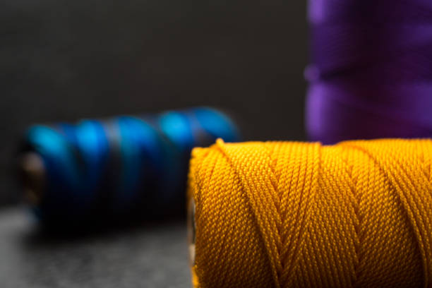 Spool of red organic cotton thread over the wood table