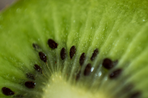 Close-up of green fresh kiwi with some black seeds