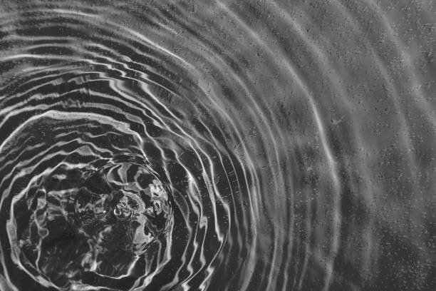 istock drops on water with circles on a black background 2130743173