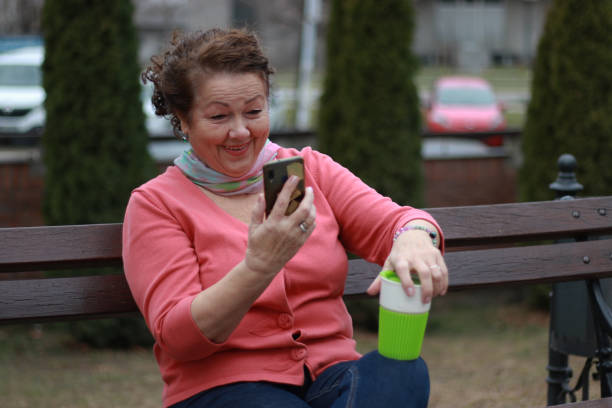 istock Senior woman relaxing and using phone and drink coffee 2130743186