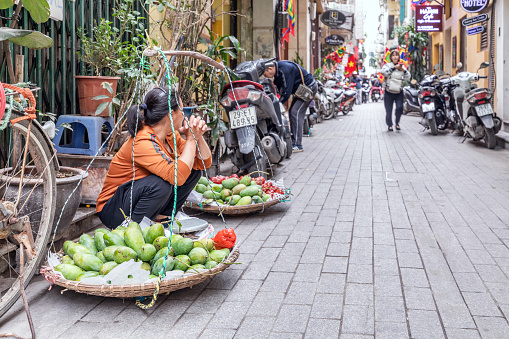 Hanoi, Vietnam - March 20, 2024: Street vendor sells mangoes on the street in downtown Hanoi