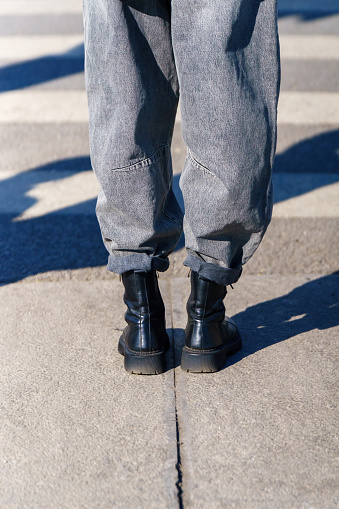 Girl's legs in wide rough pants and high leather boots