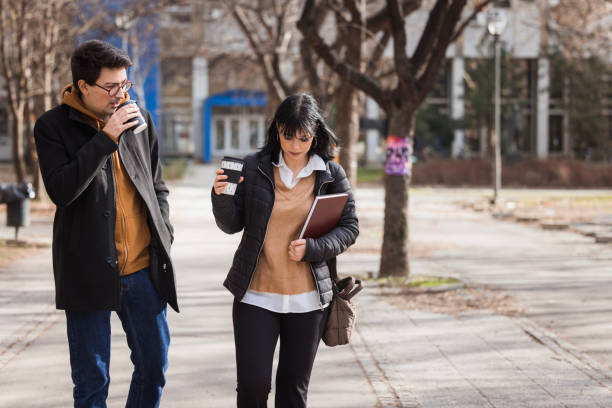 istock Student drinking coffee to go and observing his female friend 2130772915