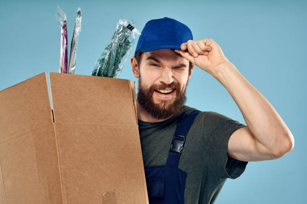 istock A man in working uniform with boxes in the hands of a carriage delivery service blue background 2130776894