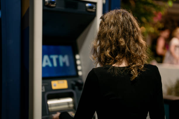 istock Girl using ATM on the street. 2130777586